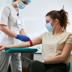Pielęgniarka przygotowuje pacjentkę do pobrania krwi. Badanie może pomóc zdiagnozować leukopenię, czyli zbyt niski poziom białych krwinek.