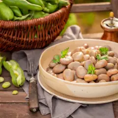 Miseczka fasolki bob, obok koszyk z zielonym bobem i otwarte strąki. Czy pies może bob? Nie, ale człowiek z apetytem!