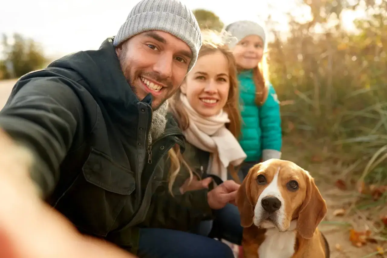 Rodzina z córką i psem rasy beagle robi sobie selfie. Może to Luna? Piękne imię dla suczki.